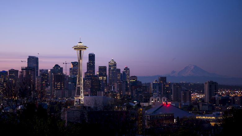 This image shows the Seattle skyline at dusk with the Space Needle prominently visible and Mount Rainier in the background.
